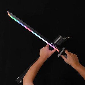 May include: A black sword with a rainbow-colored glowing edge. The handle has the text "PISONG ZHE". The sword is held against a black background.