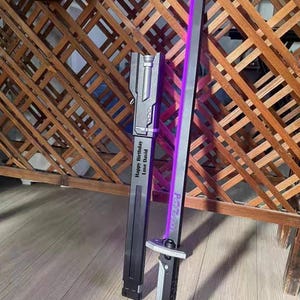 May include: A black and silver sword with a purple blade, resting on a wooden floor. The sword has the text "Happy Birthday Love David" on the sheath and "P.A.R.A.D.O.X" on the blade.
