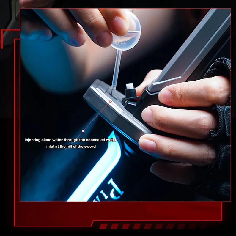 May include: A close-up of a black and gray sword being filled with water. The text on the image reads, "Injecting clean water through the concealed water inlet at the hilt of the sword."