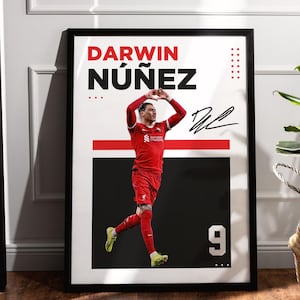 May include: Framed poster featuring soccer player Darwin Núñez in a red uniform. The poster has a black frame and includes the player's name, signature, and the number 9. The background is white and black.