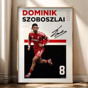 May include: Framed poster featuring Dominik Szoboszlai in a red soccer uniform, with the number 8. The poster has a black and white background with the player's name in red and a signature. The poster is displayed in a room with a window.