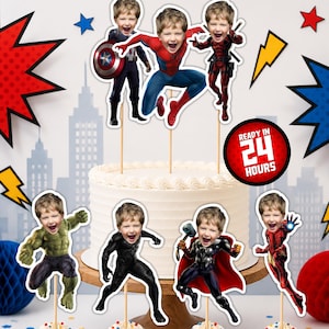 Può includere: Un set di decorazioni personalizzate per torte e cupcake con il volto di un bambino sovrapposto a vari corpi di personaggi Marvel, tra cui Captain America, Spider-Man, Deadpool, Hulk, Black Panther, Thor e Iron Man su bastoncini di legno.