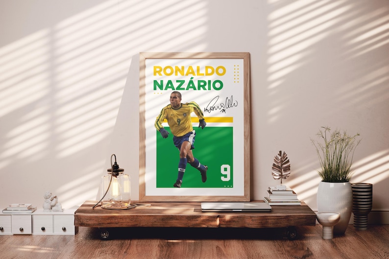 May include: A framed poster featuring Ronaldo Naz&aacute;rio in a yellow and blue soccer uniform. The poster has a green and white background with the number 9. The name "Ronaldo Naz&aacute;rio" is printed in yellow and green.