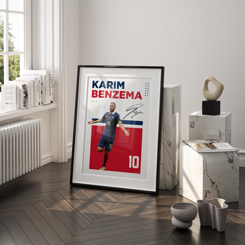 Puede incluir: P&oacute;ster enmarcado con Karim Benzema con uniforme de f&uacute;tbol azul con el n&uacute;mero 10. El p&oacute;ster tiene un fondo rojo y azul con el nombre y la firma del jugador. El marco es negro.