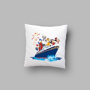 May include: White pillow with a colorful illustration of Mickey Mouse, Minnie Mouse, Donald Duck, Goofy, and Pluto on a blue and white cruise ship with red, white, and blue fireworks in the background.