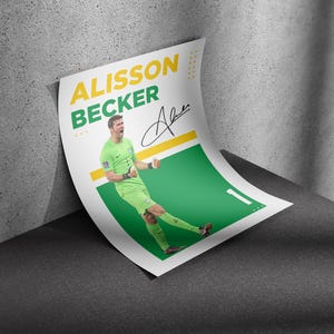 May include: A poster featuring soccer player Alisson Becker in a green uniform, with his name in yellow and green text. The poster includes his signature and a green and yellow design.