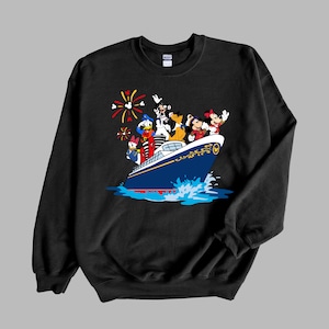 May include: Black sweatshirt with a graphic of Mickey Mouse, Donald Duck, Goofy, Pluto, and Minnie Mouse on a blue and white cruise ship with fireworks in the background.