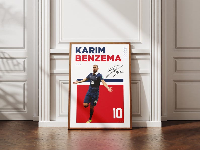 Puede incluir: P&oacute;ster enmarcado de Karim Benzema con uniforme azul, n&uacute;mero 10. El p&oacute;ster tiene un fondo rojo y blanco con el nombre y la firma del jugador. El p&oacute;ster se exhibe sobre un suelo de madera.
