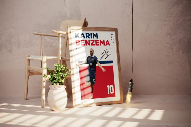 Puede incluir: P&oacute;ster enmarcado con Karim Benzema con uniforme de f&uacute;tbol azul, n&uacute;mero 10. El p&oacute;ster tiene un dise&ntilde;o rojo y blanco con el nombre y la firma del jugador. Una silla de madera y una planta en un jarr&oacute;n blanco est&aacute;n en el fondo.