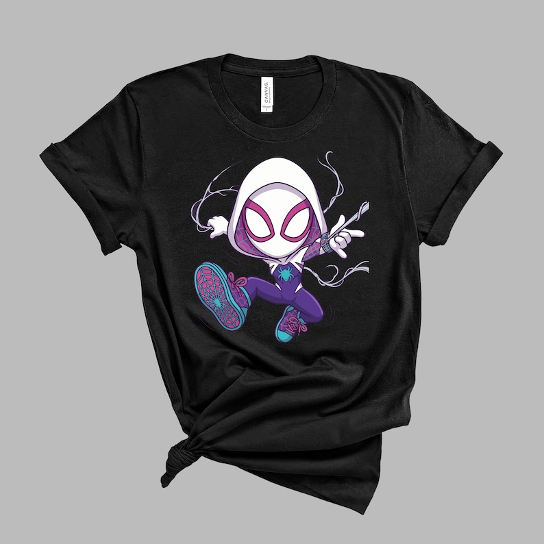 May include: A black short-sleeve t-shirt featuring a graphic of a cartoon character wearing a white hood, a purple and white suit with a teal spider emblem, and teal sneakers with pink laces, depicted in a dynamic pose with white web-like lines.