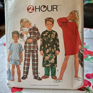 May include: Simplicity sewing pattern number 7407 for sizes AA 3, 4, 5, and 6. The pattern includes instructions for making a red dress, a plaid pajama set, and a robe with a dog print. The pattern is labeled "2 Hour" and includes a sewing time only.