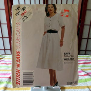 Könnte beinhalten: Ein Vintage-Schnittmuster von McCall's mit einer Frau in einem weißen Kleid mit schwarzem Gürtel. Das Muster enthält den Text "STITCH 'N SAVE" und "EASY MCCALL'S PETITE-ABLE". Die Musternummer ist 4847, Größe B.