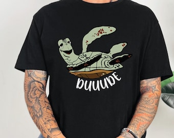 May include: Black t-shirt with a cartoon sea turtle graphic and the text "DUDE" printed on the front.