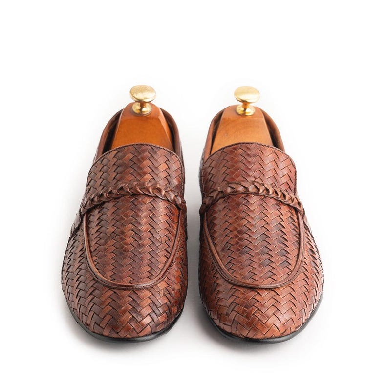 Front view of men’s woven leather loafers in rich brown finish featuring braided penny strap detail, handcrafted formal slip-on shoes, luxury business casual footwear, elegant Italian-style moccasins, and premium artisan leather loafers.