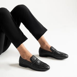 Men’s luxury woven leather loafers styled with beige trousers in modern smart casual outfit, featuring handcrafted braided leather design, elegant slip-on penny loafers, comfortable formal footwear, and sophisticated Italian-inspired men’s fashion shoes.