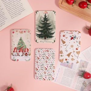May include: Four Christmas-themed gift tags. One tag features a Christmas tree with the text "Merry Christmas." Another shows gnomes in front of a Christmas tree. The other two tags have festive patterns with gingerbread men, stars, and berries.