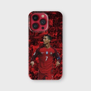 Puede incluir: Funda de tel&eacute;fono roja con la imagen de un futbolista con camiseta roja, n&uacute;mero 7. El fondo es un collage de im&aacute;genes rojas. La funda tiene un acabado brillante y un recorte para la c&aacute;mara.