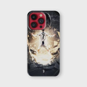 Puede incluir: Funda de tel&eacute;fono negra con un jugador de f&uacute;tbol con uniforme blanco y negro, n&uacute;mero 7 en la espalda. El dise&ntilde;o muestra al jugador rompiendo una pared con un efecto de luz brillante. La funda tiene un borde negro y un protector de lente rojo.