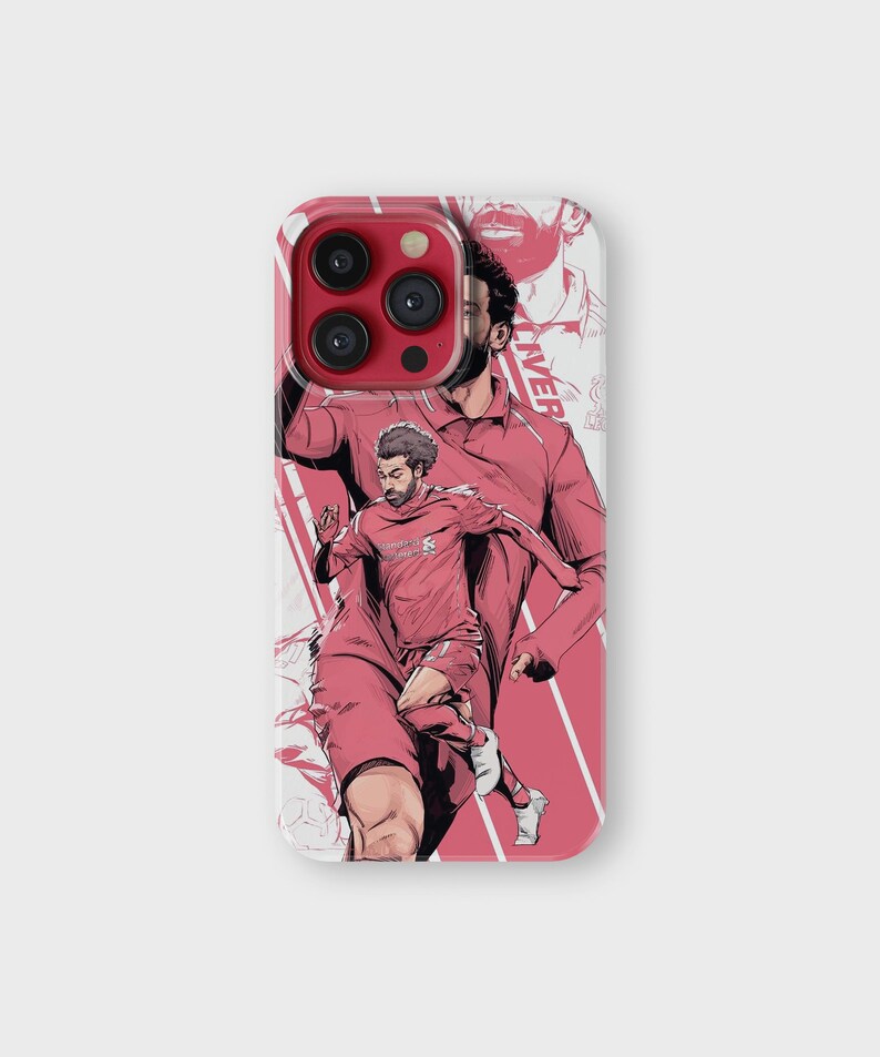 K&ouml;nnte beinhalten: Handyh&uuml;lle mit einer stilisierten Illustration eines Fu&szlig;ballspielers in roter Kleidung. Das Design zeigt eine dynamische Actionpose und einen Hintergrund mit einer &auml;hnlichen Illustration in einem helleren Rotton. Roter Kameraring.