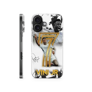Puede incluir: Una funda de teléfono blanca con una foto en blanco y negro de un jugador de fútbol que lleva una camiseta blanca con el número 7. El jugador levanta el brazo en el aire. El texto "VINI JR" está impreso en la funda.