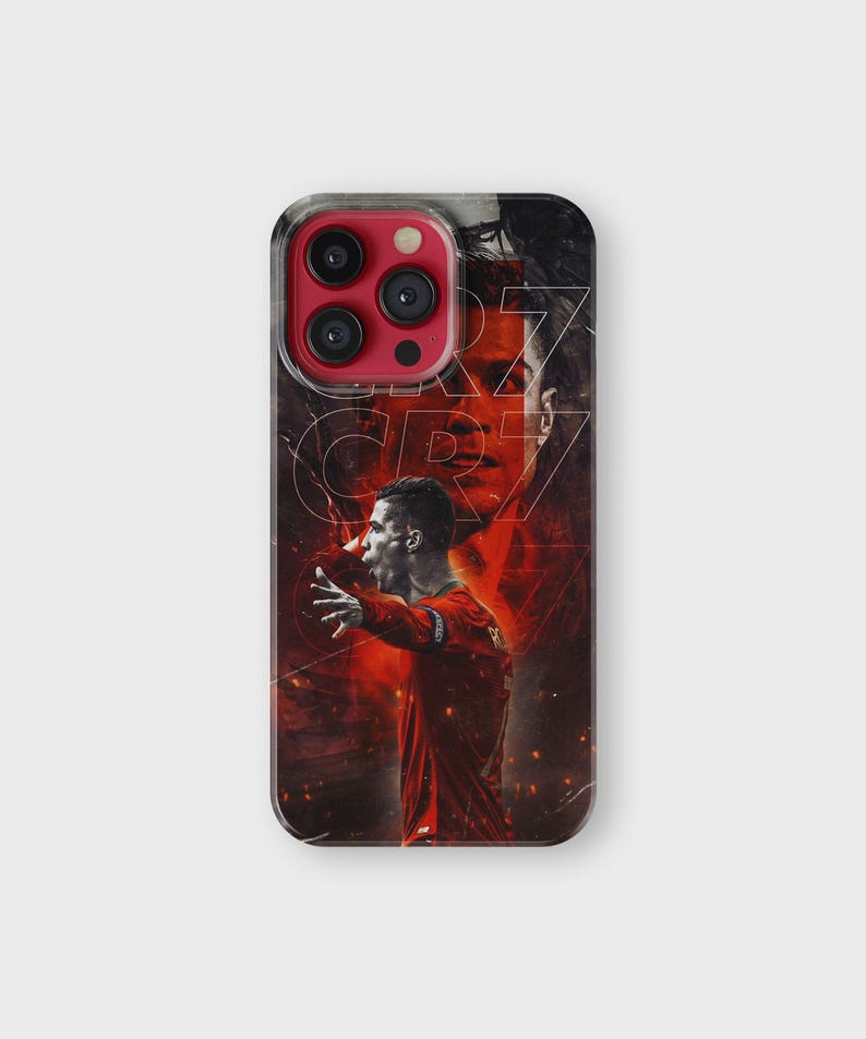 Puede incluir: Funda de tel&eacute;fono transparente con un dise&ntilde;o rojo y negro. Presenta un retrato de un futbolista con una camiseta roja, con las letras "CR7" en una fuente estilizada. El fondo tiene l&iacute;neas y formas abstractas.