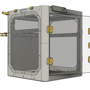 Puede incluir: Una impresora 3D gris con una puerta transparente y bisagras doradas. La impresora tiene un peque&ntilde;o panel de control en la parte superior.