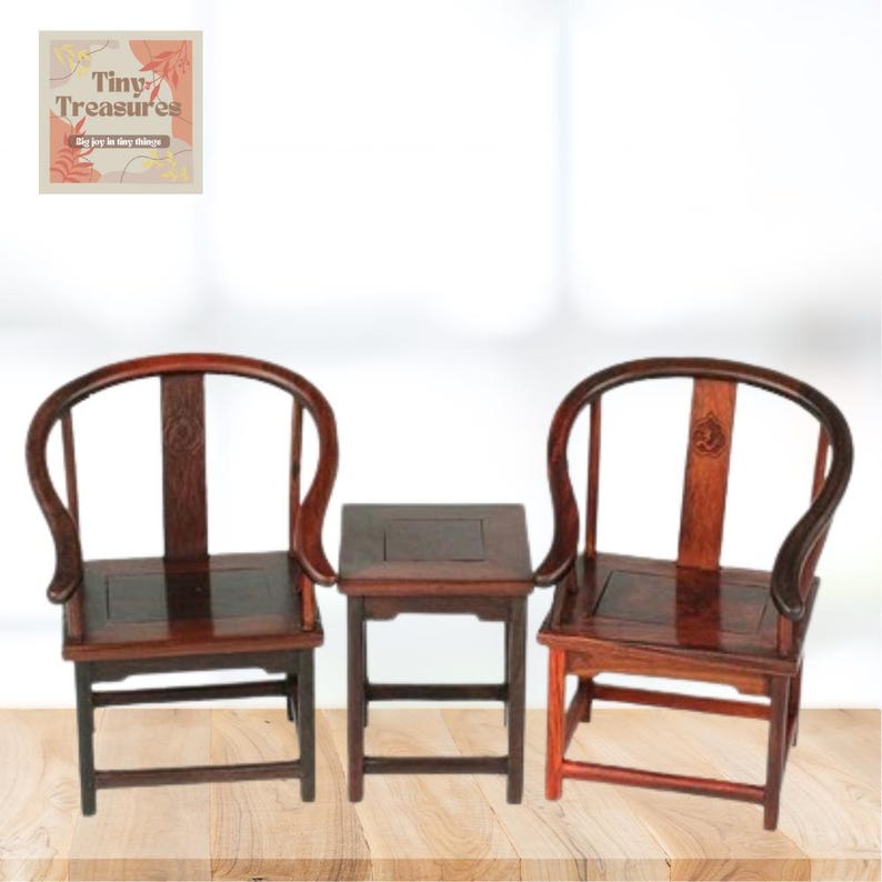 May include: A set of two dark wood chairs with curved backs and a matching square table. The chairs and table are made of dark wood with a smooth finish. The chairs have a simple design with a curved back and a square seat. The table has a square top and four legs.