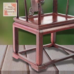 May include: A dark red wooden chair with a square seat and a simple design. The chair has a square base with four legs.