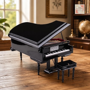 Pode incluir: Um piano de cauda preto em miniatura com um banco a condizer. O piano tem um acabamento brilhante, um teclado detalhado e partituras. O piano está sobre uma superfície de madeira, com uma janela e uma estante ao fundo.