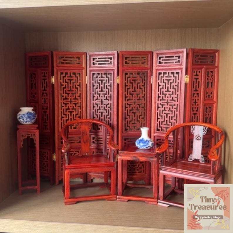 May include: A miniature red wooden room divider with intricate latticework, two red wooden chairs with curved backs, and two small red wooden tables with blue and white porcelain vases. The room divider is made of six panels and is a traditional Chinese design.