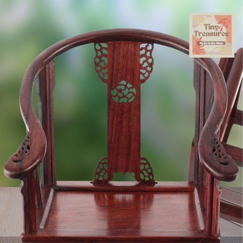 May include: A miniature wooden chair with intricate carvings and a dark reddish-brown finish. The chair has a high back and curved arms. The chair is made of solid wood and is very detailed. The chair is a miniature replica of a traditional Chinese chair.