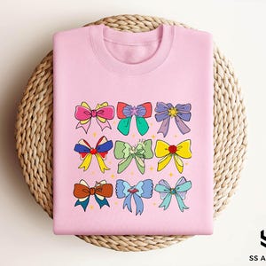 a pink tshirt with bows on it