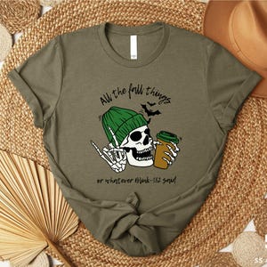 a t - shirt with a skull wearing a green hat and holding a beer