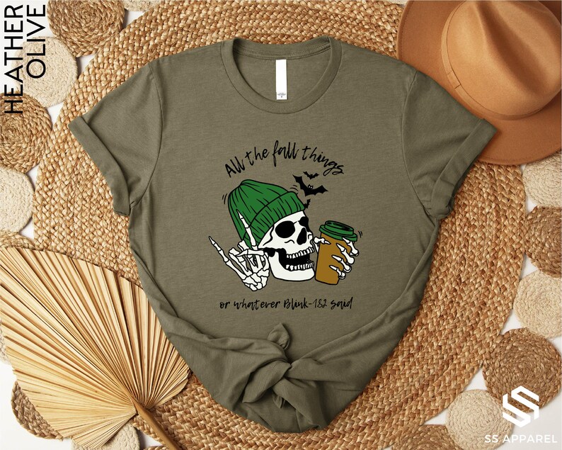 a t - shirt with a skull wearing a green hat and holding a beer