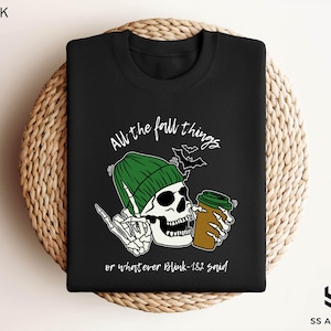 a black shirt with a skull holding a beer