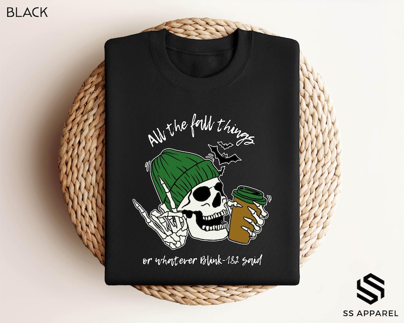 a black shirt with a skull holding a beer