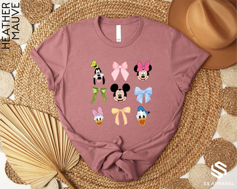 a pink tshirt with mickey mouse and other disney characters on it