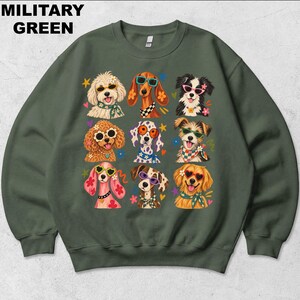 Puede incluir: Una sudadera de cuello redondo color verde militar con un estampado gr&aacute;fico de nueve razas de perros diferentes que llevan gafas de sol coloridas y pa&ntilde;uelos o collares estampados, decorada con peque&ntilde;as estrellas, corazones y flores.