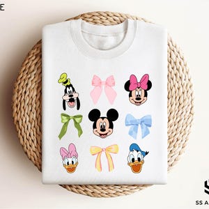 a white shirt with mickey mouse and other cartoon characters on it