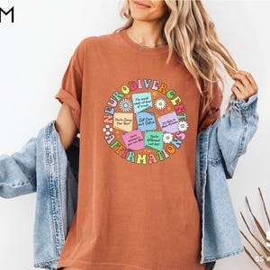 a woman wearing a brown t - shirt with words on it