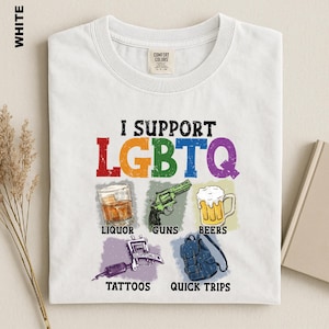 May include: A white t-shirt featuring the text I SUPPORT LGBTQ in colorful distressed letters. Below are five illustrations with labels: a glass of liquor, a green revolver for guns, a mug of beer for beers, a tattoo machine for tattoos, and a blue backpack for quick trips.