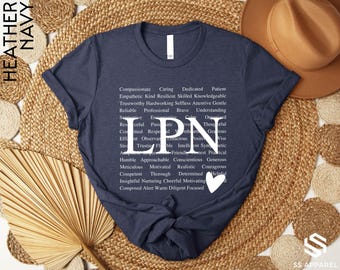 May include: A navy blue t-shirt with the word "LPN" in white letters surrounded by a list of positive adjectives describing the qualities of a Licensed Practical Nurse. The shirt has a small white heart in the bottom right corner.