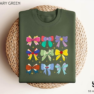 a military green shirt with bows on it