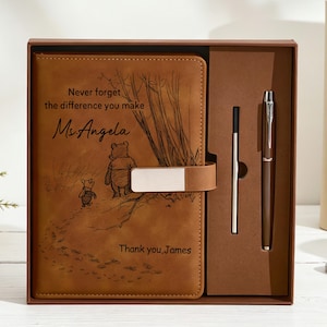 Può includere: Un taccuino in similpelle marrone con chiusura magnetica e una penna abbinata in una confezione regalo. La copertina presenta un'incisione di Winnie the Pooh e Pimpi con il testo: Never forget the difference you make Ms. Angela Thank you, James.