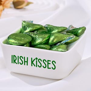 Heminredning med presenter till St. Patrick's Day, godisfat med irländska kyssar, hylldekorationer till St. Patrick's Day för hemkök, flerstegsbrickor och bordsfest.