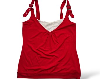 May include: A red sleeveless tank top with a white under layer and adjustable straps with silver buckles.