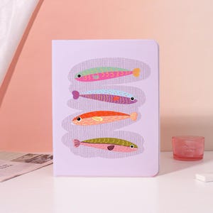 Könnte beinhalten: Ein Set aus drei Keramikbechern mit gesprenkelter, matter Oberfläche. Die Becher sind in Creme-, Hellgrau- und Dunkelgrautönen gehalten. Jeder Becher hat ein schlichtes, minimalistisches Design und einen abgerundeten Henkel.