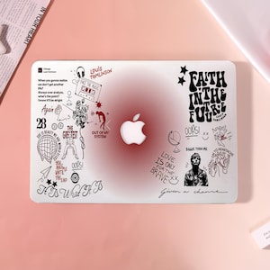 May include: A white laptop skin featuring a central red gradient circle behind an Apple logo. The surface is covered in black line art illustrations, including a cassette tape, flowers, a globe, and text such as Faith In The Future and It Is What It Is.