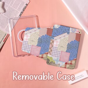 May include: A clear plastic tablet case featuring a magnetic ring and a removable cover with a collage design. The cover displays various patterns including blue cursive handwriting, red plaid, pink gingham, lace trim, and small floral motifs.