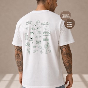 Könnte beinhalten: Ein weißes T-Shirt mit kurzen Ärmeln und einer Ansammlung dunkelgrüner Strichzeichnungen auf der Rückseite, darunter ein Gamecontroller, Surfbrett, Van, Fahrrad, Burger, Eis und das Wort DAD, mit dem Text PERSONALISIERUNG WÄHLE DEINE ICONS.